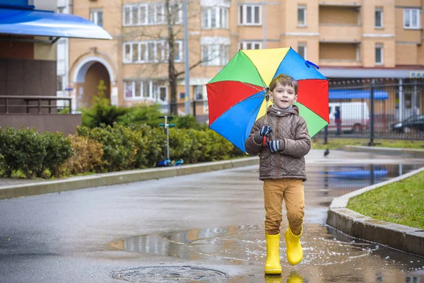 Little boy playing in rainy summer park. Child with colorful rai — Stock Photo, Image