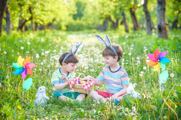 Dwóch chłopców w parku, zabawy z kolorowych jajek na Wielkanoc — Zdjęcie stockowe