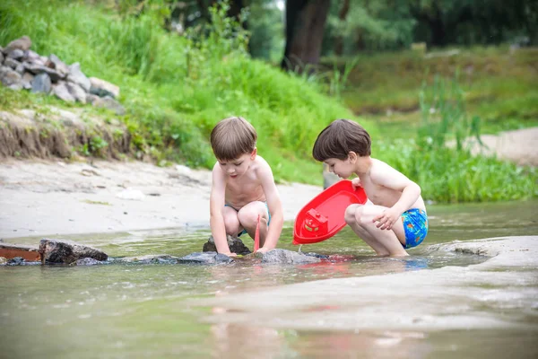 Two blond brothers are having fun on the beach in a sunny summer day Stock Photo