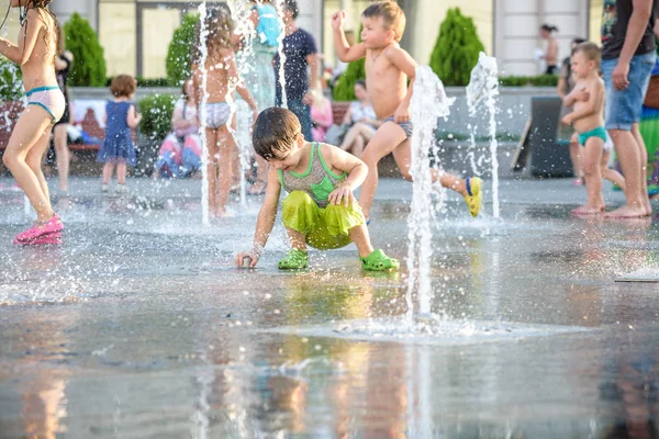 KYIV, UKRAINE Agosto 13, 2017: Crianças felizes se divertem brincando na fonte de água da cidade no dia quente de verão . — Fotografia de Stock