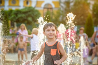 heyecanlı çocuk su jetleri, Çeşme arasında eğleniyor. Şehirde yaz