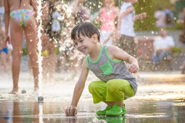 Chico excitado divirtiéndose entre chorros de agua, en la fuente. Verano i — Foto de Stock