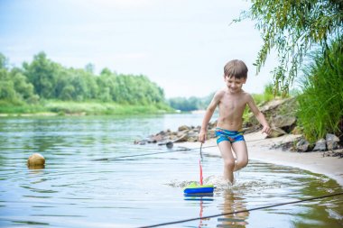 Denizde gemi oyuncakla oynamak bebeğim. Sahilde tatil tatil yaz çocuk os