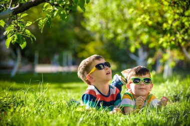 Mutlu gülümseyen erkek kardeş kardeşi çimenlerin üzerinde rahatlatıcı. Kopya alanı görünümüyle kapatın.