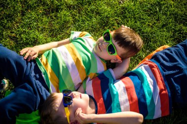 Bir çim üzerinde giyen söylenen döşeme mutlu neşeli gülümseyen çocuklar