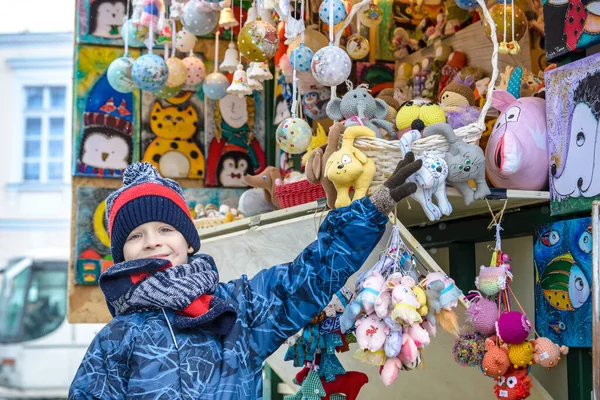 Kleiner süßer Junge bei der Dekoration auf dem Weihnachtsmarkt. werden — Stockfoto