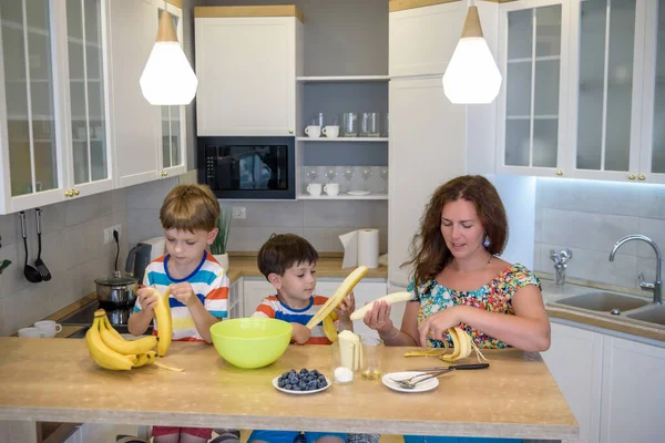 Jeune mère et ses deux enfants à biscuits de cuisine — Photo