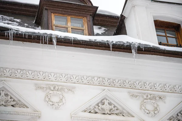 Garlands of icicles, hanging down from roofs of an ancient white stone fortress walls and towers, appear like a graceful seasonal decor made by nature