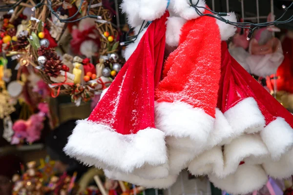 市場でラックに雪の結晶の赤いサンタ帽子を販売、正月やクリスマス休暇 — ストック写真