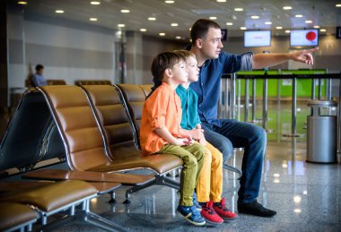 Anne ve iki kardeş oğul uçakları indirmeyi işaret ediyor. 