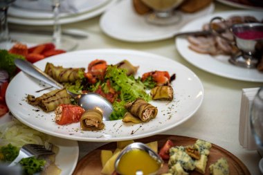 Beyaz seramik plaka ızgara patlıcan süslenmiş salatalık ve maydanoz dilimleri dolu çizik koyu beton yatıyor