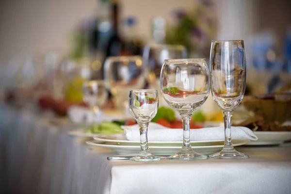 Okulary, widelce, noże, serwetki i dekoracyjnych kwiatów na stole serwowane na obiad w przytulnej restauracji. — Zdjęcie stockowe