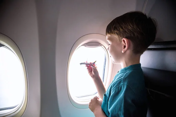 Милий маленький хлопчик подорожує літаком. Дитина сидить на літаку — стокове фото