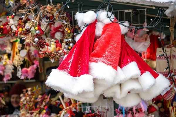 市場でラックに雪の結晶の赤いサンタ帽子を販売、正月やクリスマス休暇 — ストック写真