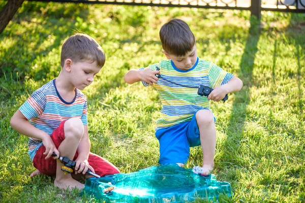 Dos chicos jugando con un juguete para niños. Popular torneo de juegos para niños . — Foto de Stock