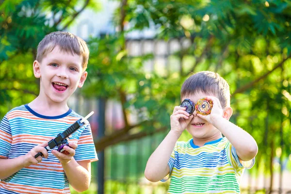 2人の少年がスピニングトップキッドのおもちゃで遊んでいます。人気の子供ゲーム大会. — ストック写真