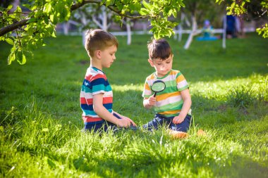 Güneşli bir günde elinde büyüteçle kağıt üzerinde ateş yakan iki sevimli çocuk. Bahçede ateş doğasını keşfeden çocuk. Büyüteci olan genç bir kaşif. Eğitim ve keşif kavramı