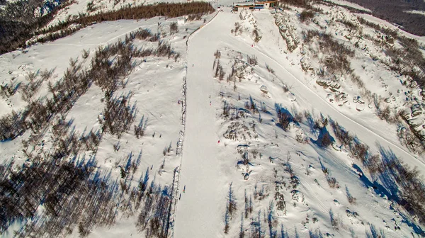 Skifahrer und Snowboarder rutschen in der Nähe des Lake Bannoe den Berghang hinunter. Antenne — Stockfoto