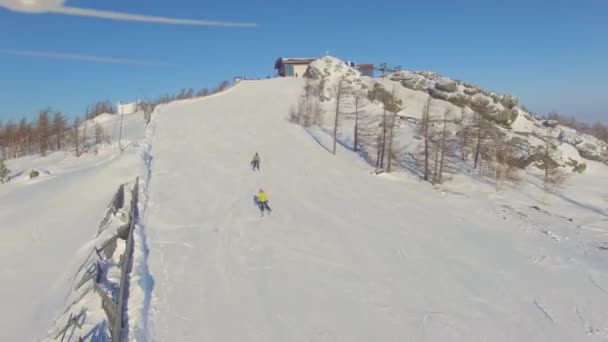 Лыжники и сноубордисты спускаются с горы возле озера Банное. Воздушный — стоковое видео