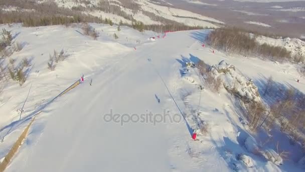 Síelők és snowboardosok csúszik lefelé a hegyoldal repülőtérhez közeli szálláshelyek: lake Bannoe. Légi — Stock videók