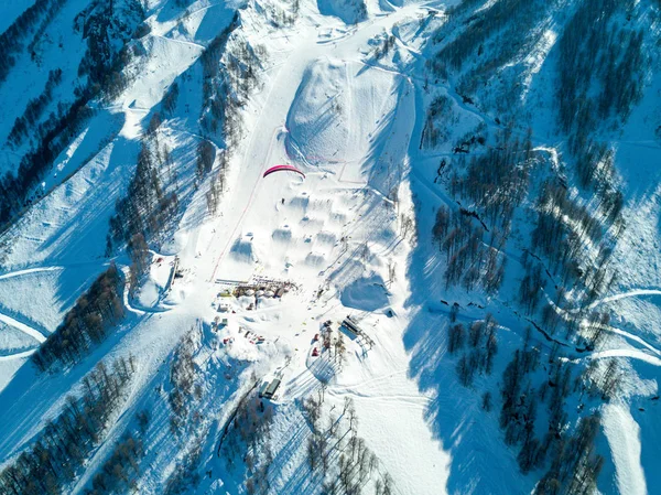 Parapente voa sobre as montanhas sobre a estância de esqui — Fotografia de Stock