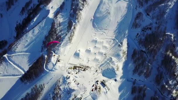 Padákového kluzáku létá nad horami přes lyžařské středisko — Stock video