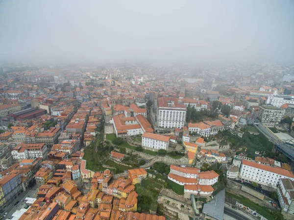 Flight over the narrow streets of the old town of Porto at the fog — Stock Photo, Image