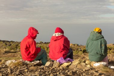 Üç adam Kilimanjaro Dağı yamacında radyo dinlemek