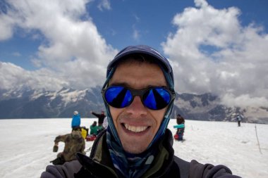 Bir adam selfie Elbruz Dağı yhe eğimi yapar.