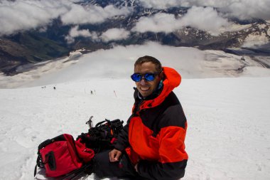 Bir adam selfie Elbruz Dağı yhe eğimi yapar.