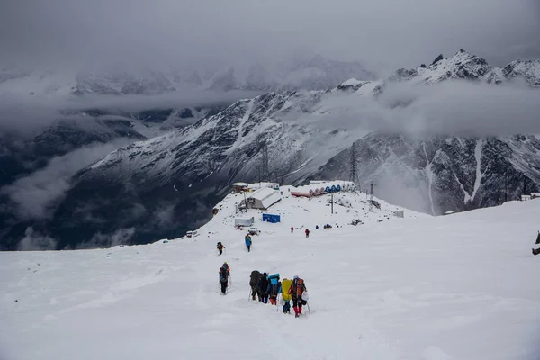 Skupina lidí klesá od Mount Elbrus do základního Garabashi — Stock fotografie