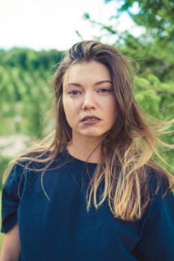 Genç kahverengi vahşi saçlı kadın öğrenci park güneşli havalarda sahiptir