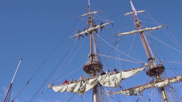 Sailors work with sails at a height on a traditional sailboat — Stock Video