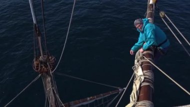 Denizciler iş geleneksel bir yelkenli üzerinde bir yükseklikte yelkenli
