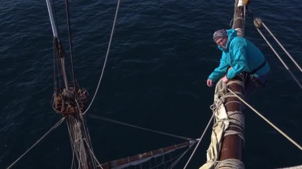 Zeilers werken met zeilen op een hoogte op een traditionele zeilboot — Stockvideo
