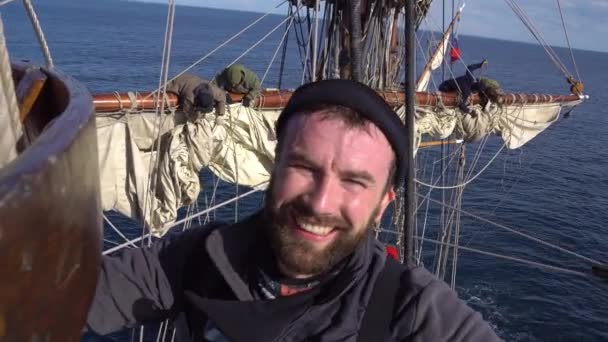 Der Matrose lächelt in der Höhe auf einem Segelboot — Stockvideo