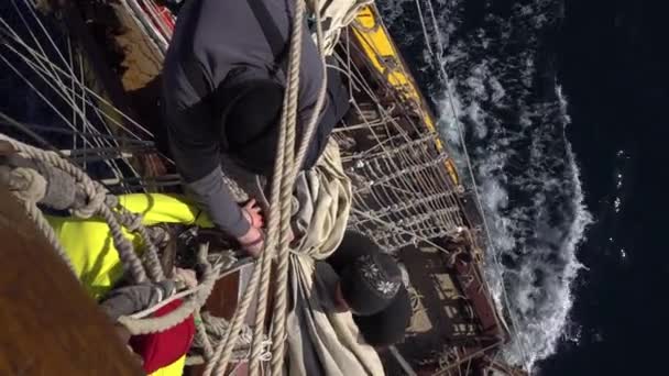 Los marineros trabajan con velas a una altura en un velero tradicional — Vídeos de Stock