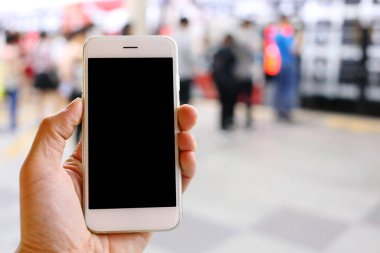 Metro istasyonunun arka planında akıllı telefon var.