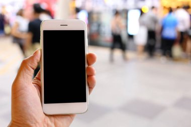 Metro istasyonunun arka planında akıllı telefon var.