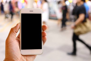 Metro istasyonunun arka planında akıllı telefon var.