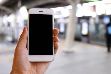 Metro istasyonunun arka planında akıllı telefon var.