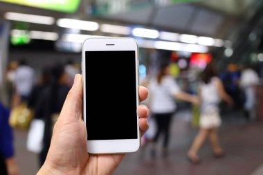 Metro istasyonunun arka planında akıllı telefon var.
