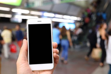 Metro istasyonunun arka planında akıllı telefon var.