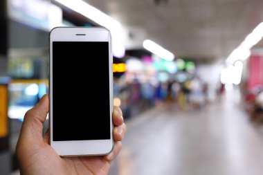 Metro istasyonunun arka planında akıllı telefon var.