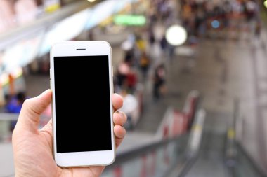 Metro istasyonunun arka planında akıllı telefon var.