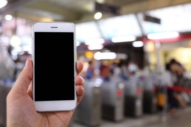 Metro istasyonunun arka planında akıllı telefon var.