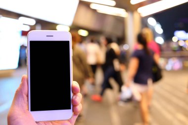 Metro istasyonunun arka planında akıllı telefon var.