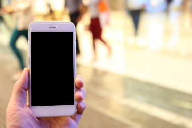 Metro istasyonunun arka planında akıllı telefon var.