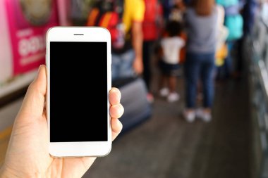 Metro istasyonunun arka planında akıllı telefon var.