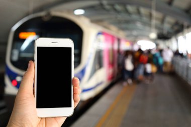 Metro istasyonunun arka planında akıllı telefon var.